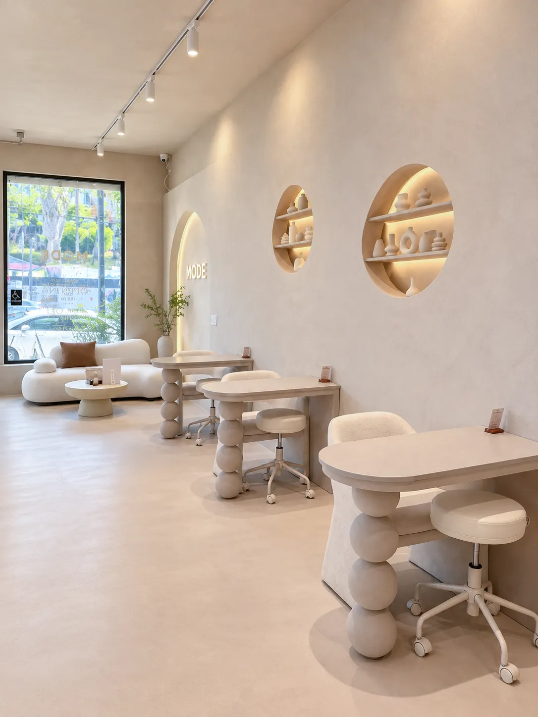 Manicure stations with sculpted tables beside the front window